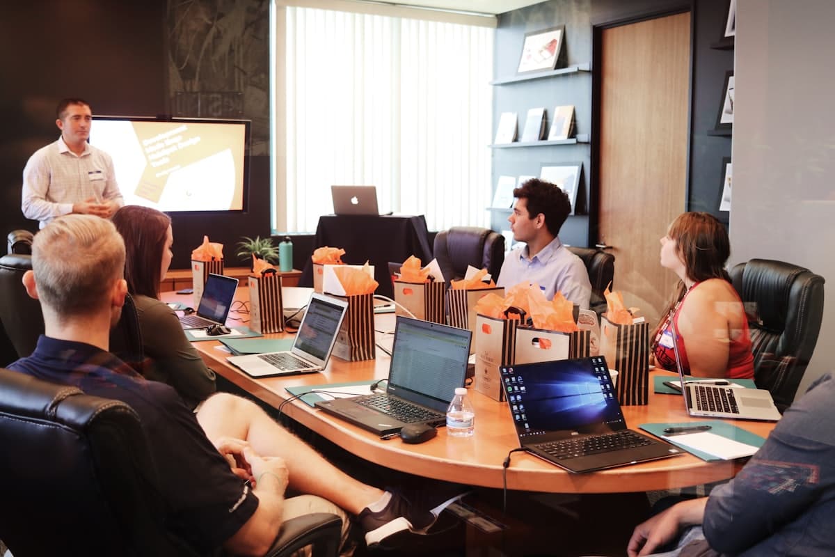 Equipo de negocios reunido alrededor de una mesa de conferencias con laptops